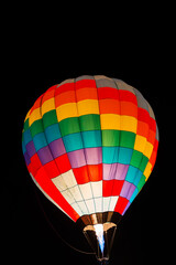 colorful hot air balloons glowing against dark night sky