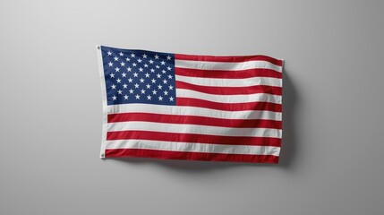 Obraz premium The United States of America national flag waves proudly against a neutral gray background showcasing patriotism and national pride beautifully.