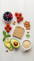 Healthy breakfast ingredients arranged on a clean white surface including avocado, bread, and fresh cherry tomatoes from a top-down view