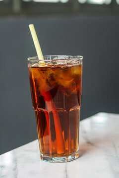 One tall glass of iced tea on a marble surface. Captured with natural light.