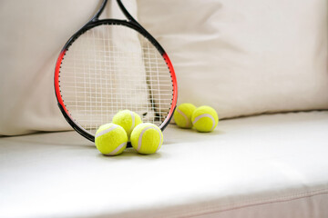 Tennis Racket and Tennis Balls with Soft Cool Tone on White Sofa