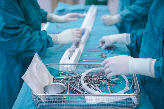 Surgical team preparing Physician Modified Endovascular Graft (PMEG) delivery system in operating room.