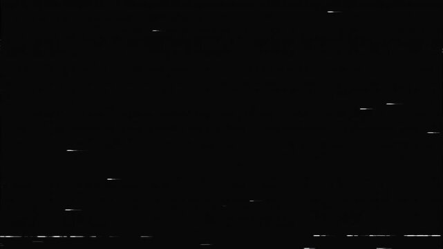 Sparse white dashes and specks move across a black background, simulating light dust or minor magnetic tape damage