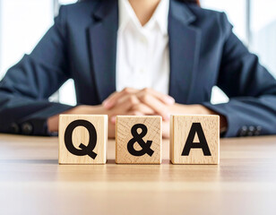 Generative AI
ビジネスシーンのQ&Aイメージ 木製ブロックと女性の手元