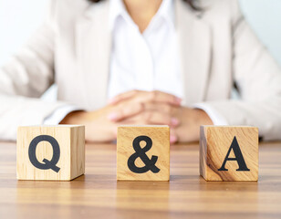 Generative AI
ビジネスシーンのQ&Aイメージ 木製ブロックと女性の手元