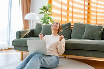 Funny euphoric young asian woman celebrating winning or getting ecommerce shopping offer on computer laptop. Excited happy girl winner looking at notebook celebrating success