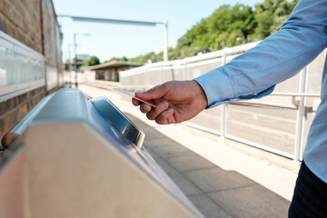 Businessman using credit card to pay for train ticket at station