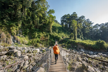 Mountain guide crossing suspension bridge during a hike in Rwenzori Mountains, Uganda  © MatousVins