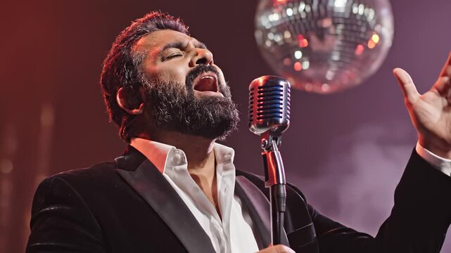 Man singing into microphone on stage