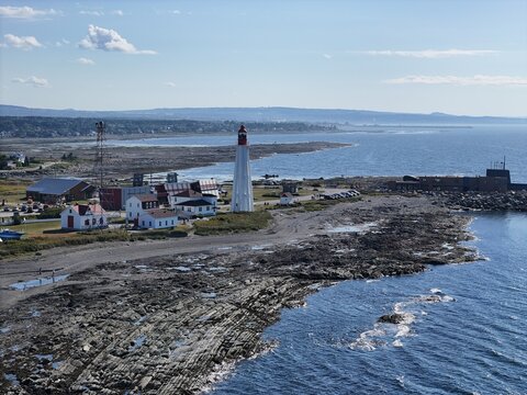 Aerial view of Pointe au Pere lighthouse near Rimouski on rocky coastline, Quebec, Canada, summer daylight. g.
