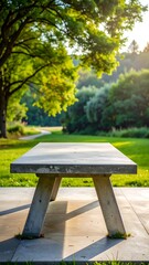 Fototapeta premium A serene outdoor scene featuring a wooden table on a stone patio surrounded by lush greenery and a tree