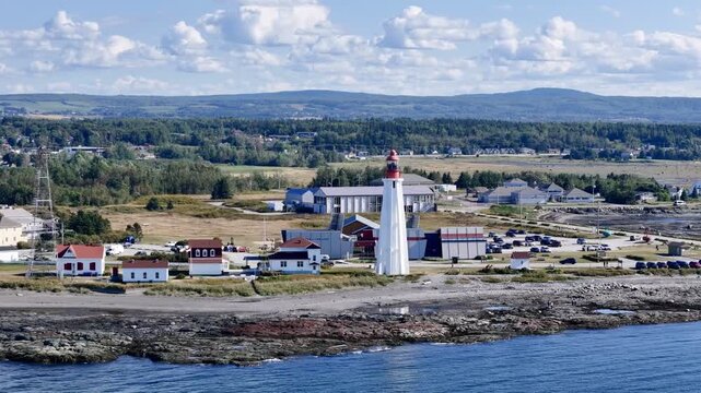 Aerial view of Pointe au Pere lighthouse near Rimouski on rocky coastline, Quebec, Canada, summer daylight. g.