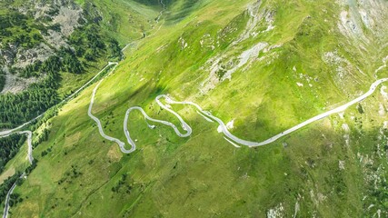 Stunning aerial view of a winding road through lush green mountains. Ideal for travel brochures and...