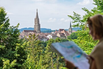 A tourist studies a map while enjoying a stunning view of Freiburg im Breisgau, Germany. The...