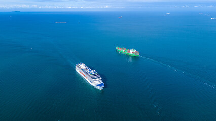 Naklejka premium a large luxury cruise ship sailing in the deep blue ocean. White passenger vessel featuring swimming pools on the top deck. Summer vacation and international tourism concept.
