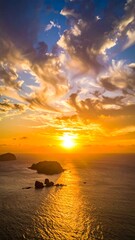 A serene aerial view of a sunset over a vast body of water with scattered land formations