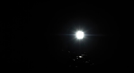 A camera flash illuminates a dark environment, momentarily capturing movement or a static scene with a burst of bright light ,image ,visual ,still