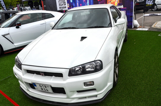 Striking white Nissan Skyline GT-R R34 renowned for its technological prowess and sleek, timeless design, true icon of Japanese automotive engineering
