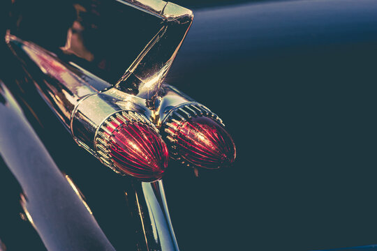 Close up of a vintage American car's plastic and metal, pointy tail lights - horizontal
