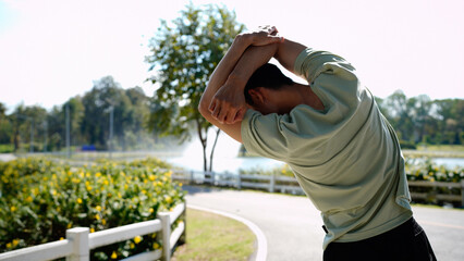photo of a man stretching before running in a park, wearing sportswear, Outdoor Fitness and Wellness Activities in Natural Setting