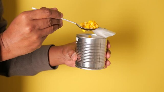 Hand holds a can with a paper on top of it