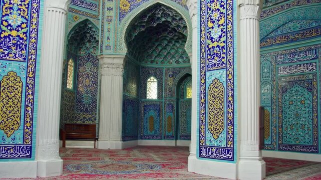 An ornately decorated interior of a religious building, featuring intricate tilework & columns