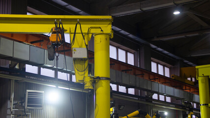 LED lighting projector in a dark production workshop, ventilation devices, windows and concrete structures