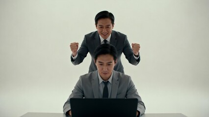 Two men in suits one seated one standing