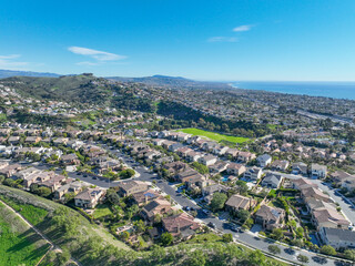 Obraz premium Aerial view over San Juan Capistrano, California, featuring the historic mission, library, sports courts, and an Amtrak train pulling into the downtown station. High quality 4k footage