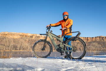 Obraz premium senior male cyclist with a touring electric bike in Colorado foothills in winter scenery