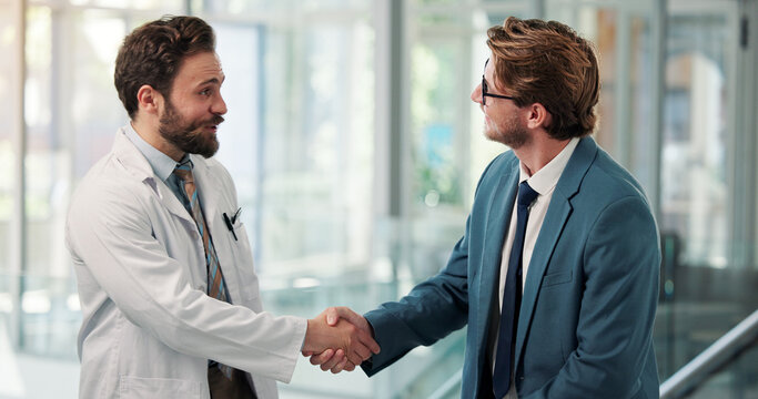 Men, doctors and shaking hands at clinic, lobby and happy with agreement, thanks or hiring. People, medical staff and handshake for success, goal or congratulations for onboarding in hospital hallway
