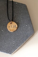 Minimalist Handmade Bronze Necklace with FREE Inscription on Concrete Surface A Symbol of Liberty.