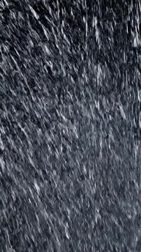 Abstract vertical shot of falling water. Gray tones. Motion, light and darkness blend together