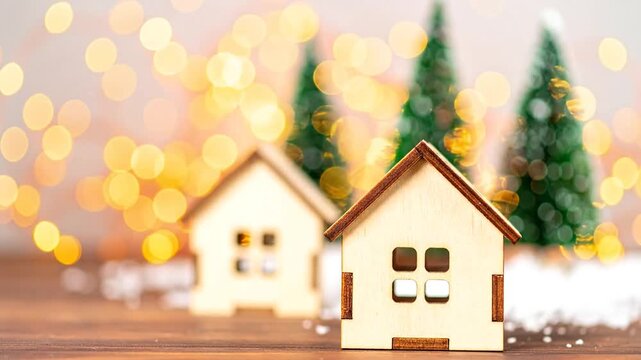 Wooden houses and green trees with a bokeh background suggesting a holiday or winter scene