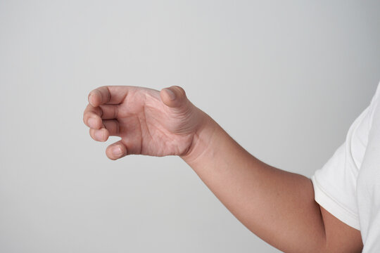 Male person hand holding something empty, over grey