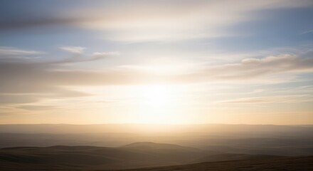 Obraz premium Brilliant golden sunlight illuminates rolling hills and a vast sky at dusk or dawn.