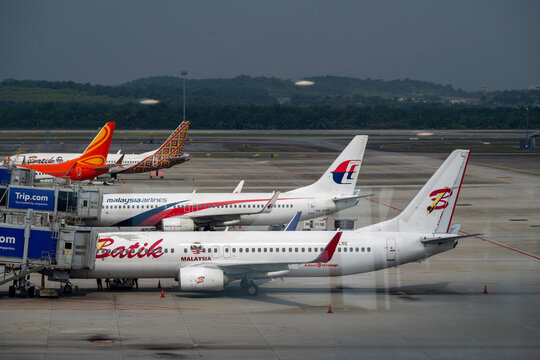 General view of Batik Air and Malaysia Airlines commercial aircraft parked at the aerobridges on the tarmac of Kuala Lumpur International Airport (KLIA) on January 18, 2026 in Sepang, Malaysia.