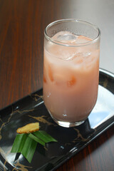 Cold pink guava milk with pandan and ginger on tray