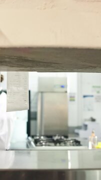 Chef, hands and reading in restaurant kitchen with receipt, customer order and meal preparation. Woman, check invoice and food slip in diner for hospitality service, cooking and catering request.