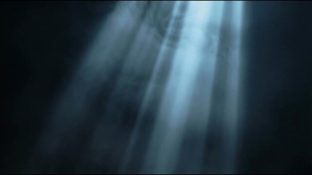 Volumetric light animation with cool blue gray rays descending through dark atmospheric space as soft mist drifts gently creating a calm cinematic and realistic visual mood