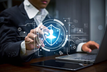 Business professional using laptop with holographic cybersecurity interface, digital shield, data protection icons, cloud security, and user authentication concept for modern technology and informatio