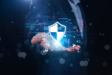 Businessman holding glowing digital shield with cybersecurity icons, data protection symbols, warning alerts, login interface, and secure network concept for online safety and information security tec