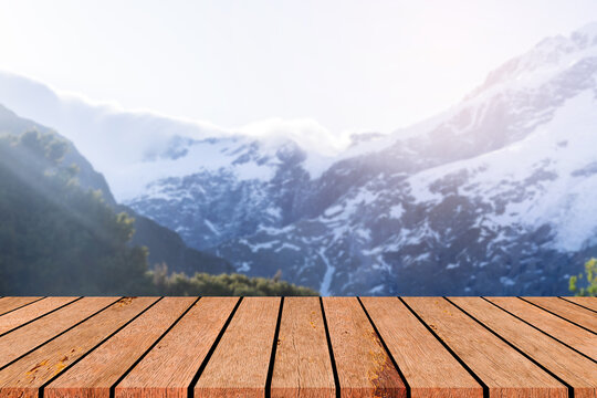 blur beautiful snow mountain peak with glacier landscape background with  perspective wood table top for show and promote goods,product on retail display concept
