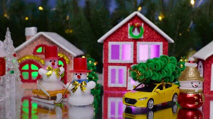A Christmas town with a yellow car and snowmen in the center
