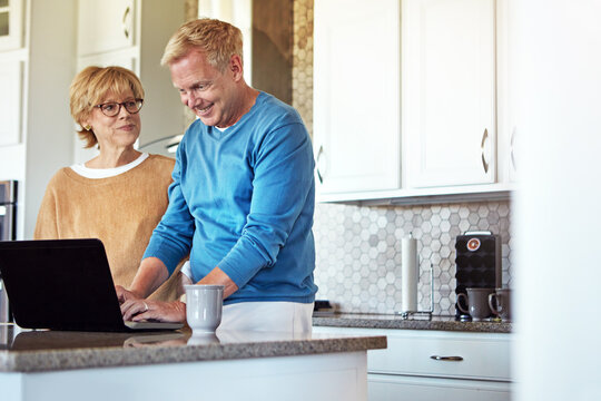 Laptop, plan and search with old couple in kitchen for retirement trip, bucket list destination or love. Travel itinerary, senior vacation and online with elderly man and woman in home for ticket