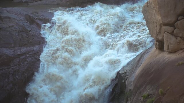 Slow motion of here river going over a waterfall