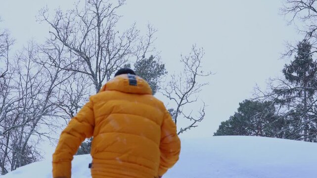 A man travels in the mountains in winter. Traveler raising arms victoriously. The concept of travel and active lifestyle. 4K