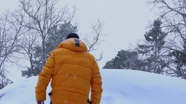 A man travels in the mountains in winter. Traveler raising arms victoriously. The concept of travel and active lifestyle. 4K