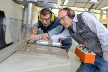apprentice working on machine with mentor