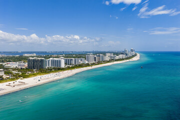 Miami beach with turquoise waters. Aerial view of sandy coastline and waves. Tropical Miami Beach scene with sandy beach. Oceanfront of South Miami. Panoramic of Miami Beach.